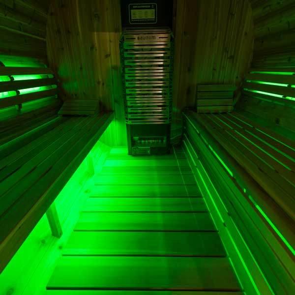 Double Bench Light Set showing green LED strips glowing beneath dark wooden sauna benches and along the floor