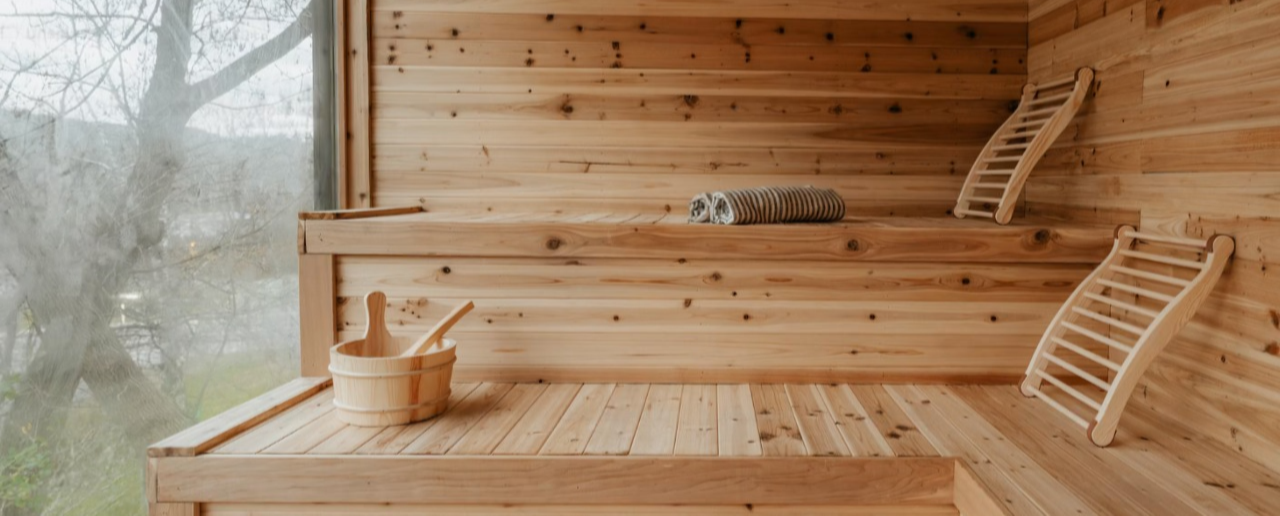 Luxury Cedar Sauna Interior with Wooden Benches, Bucket, and Natural Light – Relaxing Spa Atmosphere