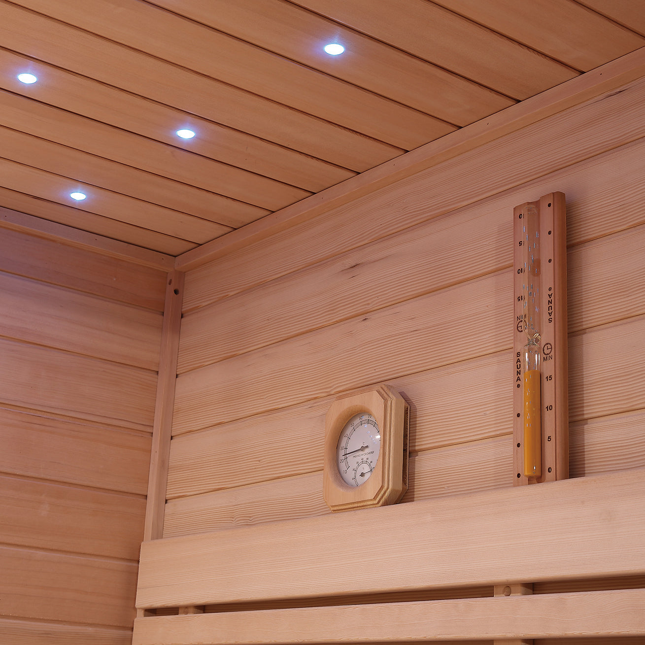 Blue LED ceiling lighting and thermometer inside Hemlock wood Waja I002 sauna