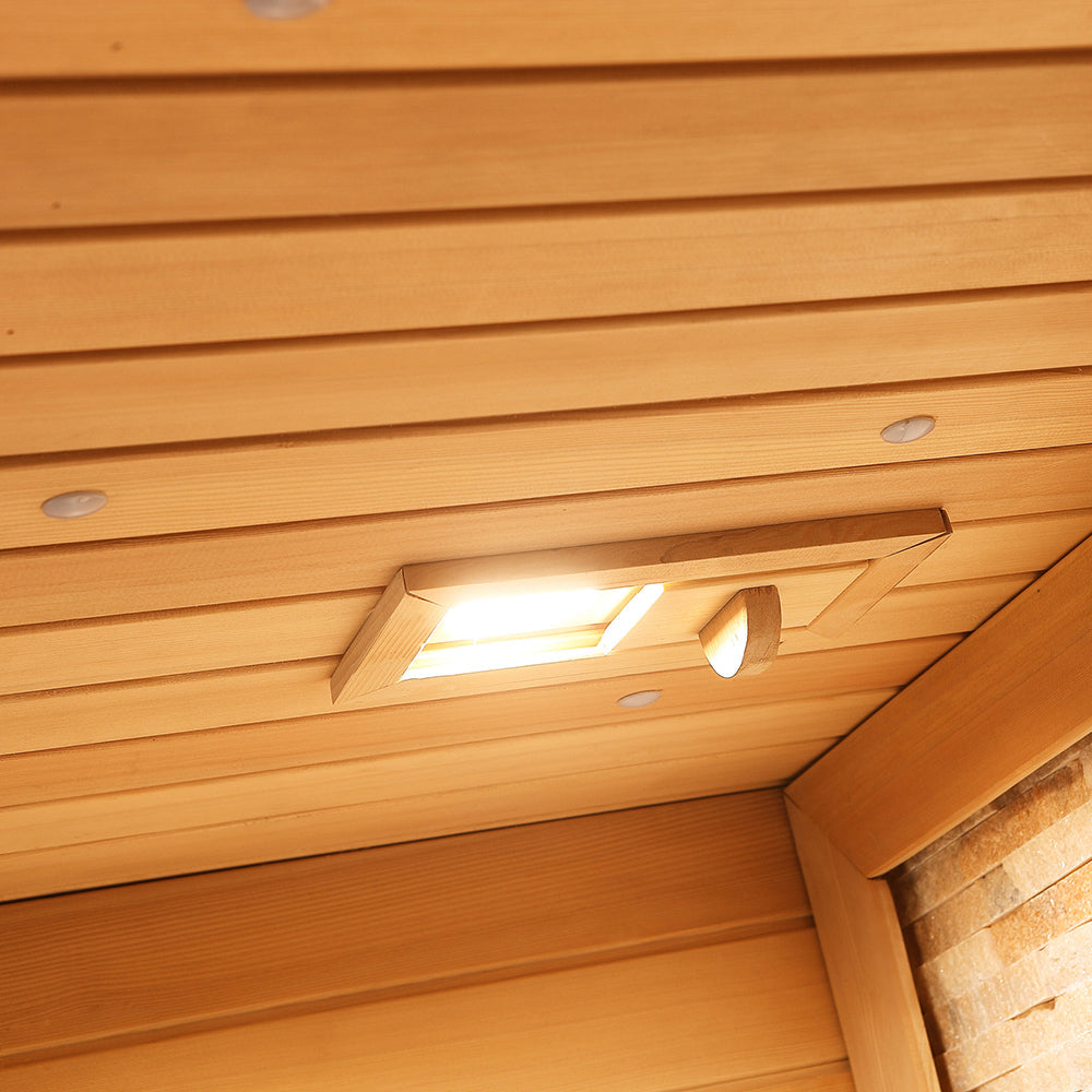Interior view of soft ceiling light fixture recessed in sauna’s wooden paneling
