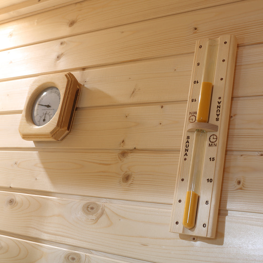 Interior wall-mounted thermometer and sand timer in Waja sauna for heat and session monitoring