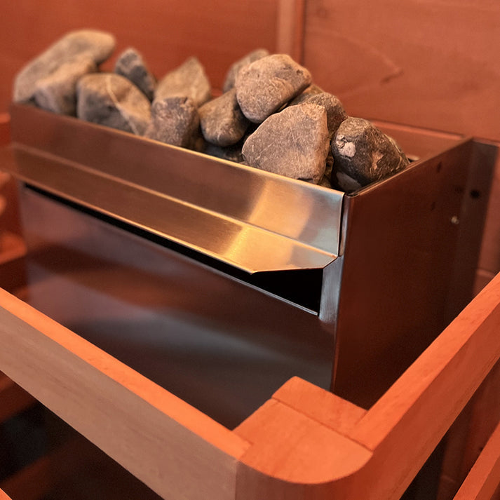 Close-up of the Scandia 9KW Electric Sauna Heater with sauna stones for an authentic steam experience.